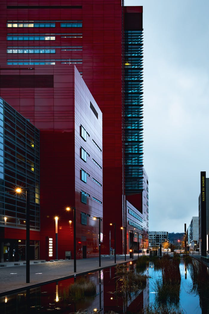 Contemporary red buildings reflecting in water in Luxembourg's cityscape.
