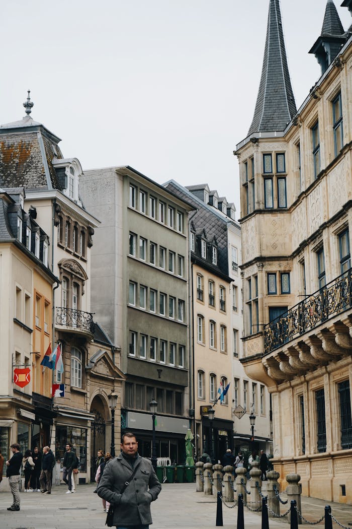 Historic architecture and pedestrians in Luxembourg City center on an overcast day.